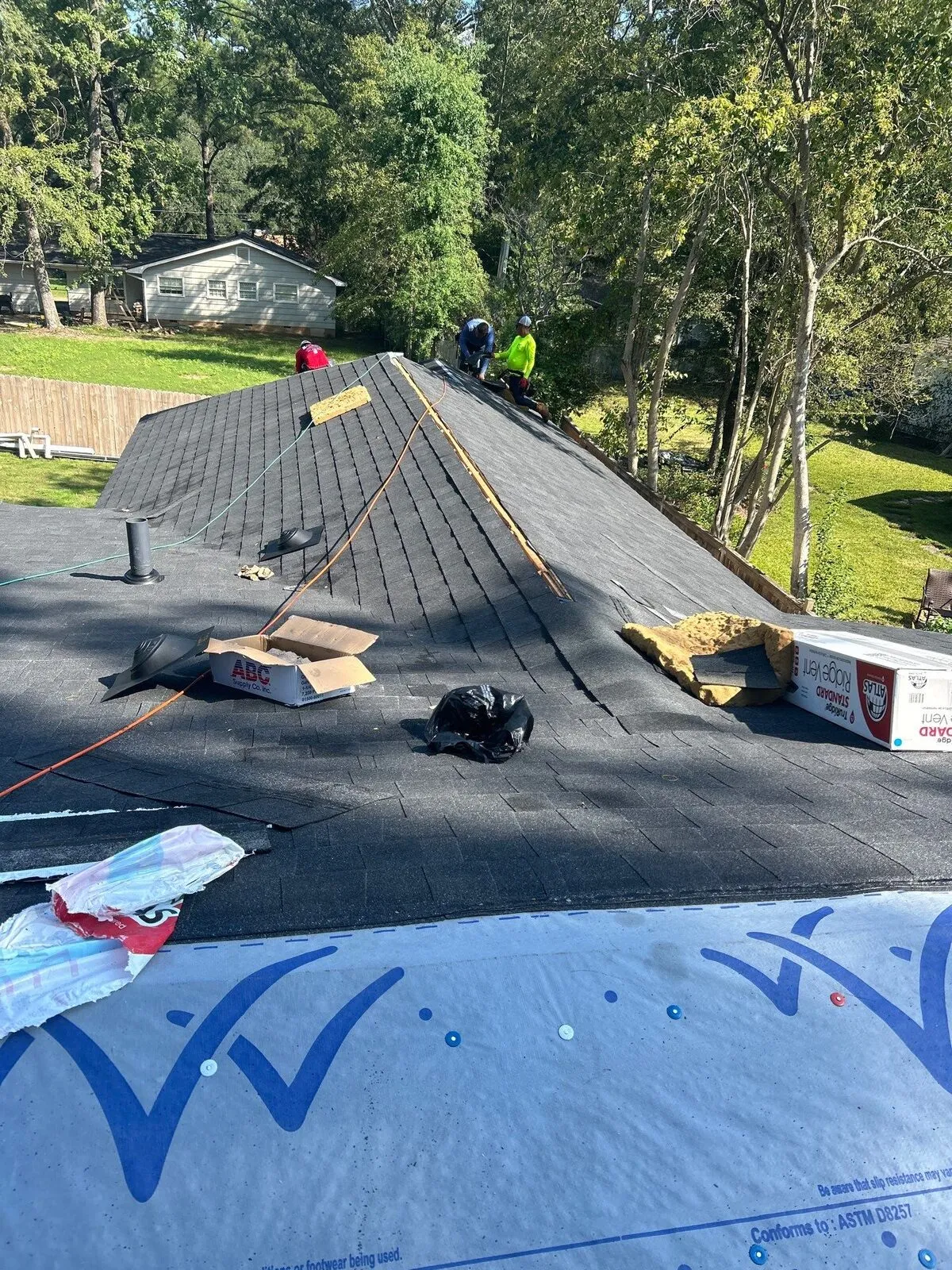 Dickerson crew re-shingling a ridge with vent boxes staged