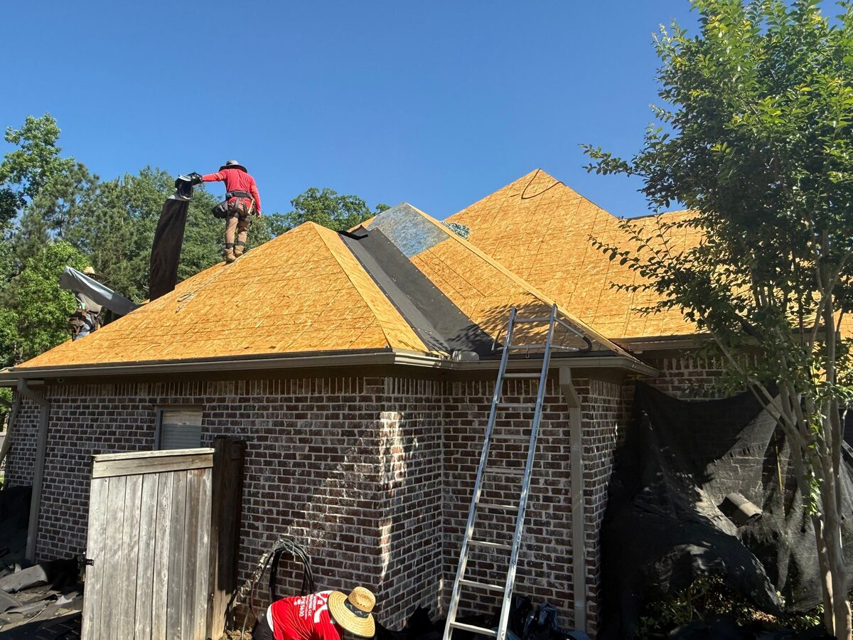 Dickerson roofer working fresh decking on a brick home mid-install